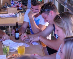 People gathered around a table playing bar trivia.