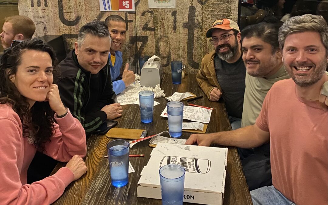 Happy people sitting at a table after winning trivia