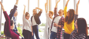 Banner of Young multiethnic diverse creative asian group huddle and high five hands together in office workshop with success or empower expression in teamwork. Young asian marketing team.